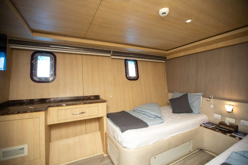 Compact cabin with a single bed and portholes aboard the Captain Sparrow