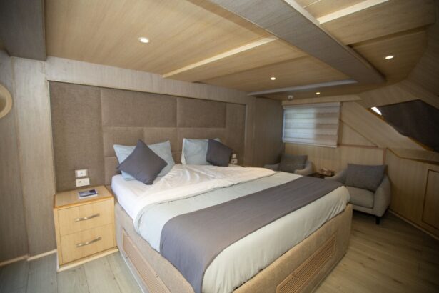 Double cabin with taupe upholstered headboard and armchair aboard the Captain Sparrow