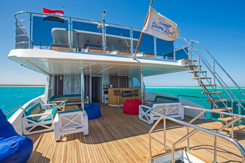 Upper deck of the Dolce Vita liveaboard with lounge seating and the Divers Fleet flag flying