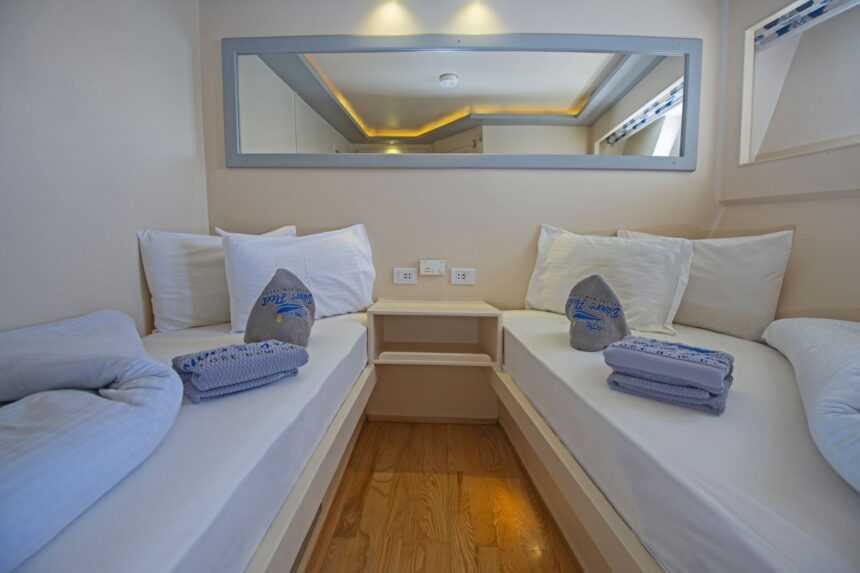 Twin cabin on the Dolce Vita with made-up beds, mirror and folded towels