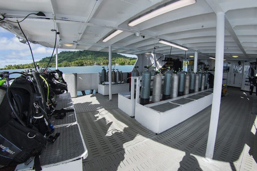 Scuba tanks and gear staged on the Odyssey liveaboard's dive deck