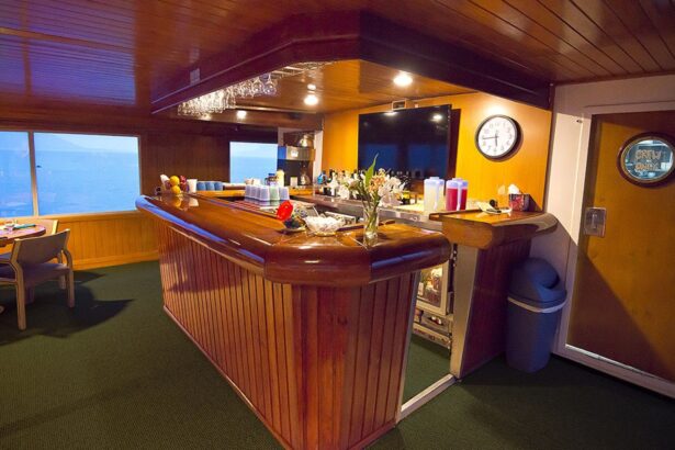 Wooden bar with a clock and wine glasses aboard the Odyssey liveaboard