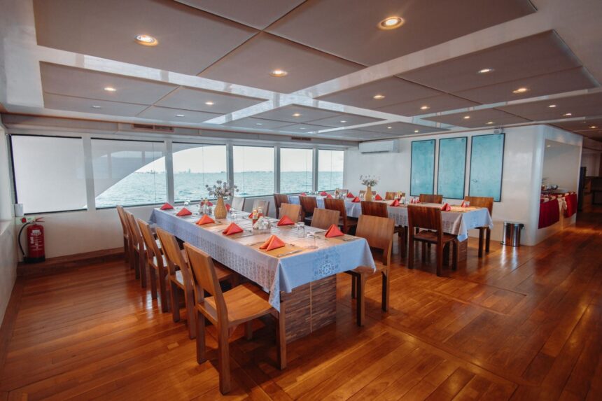 Dining area with long tables set for a group meal on the Adora