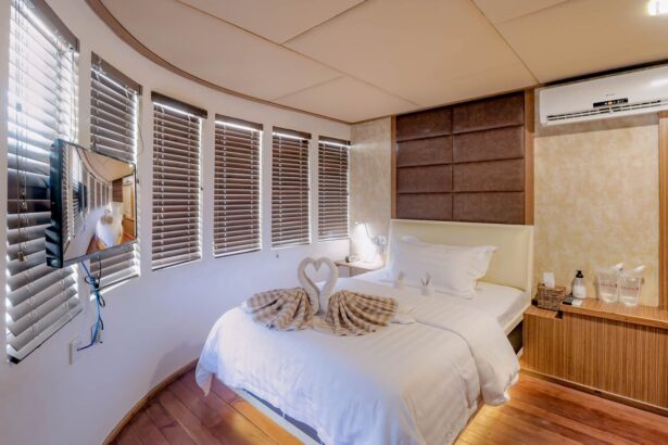 Cabin bed with towel swan decoration and window blinds aboard the Adora