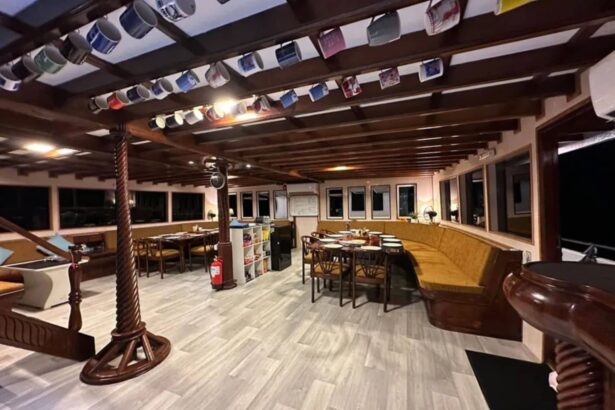 Evening lounge and dining area strung with hanging mugs aboard the Amba
