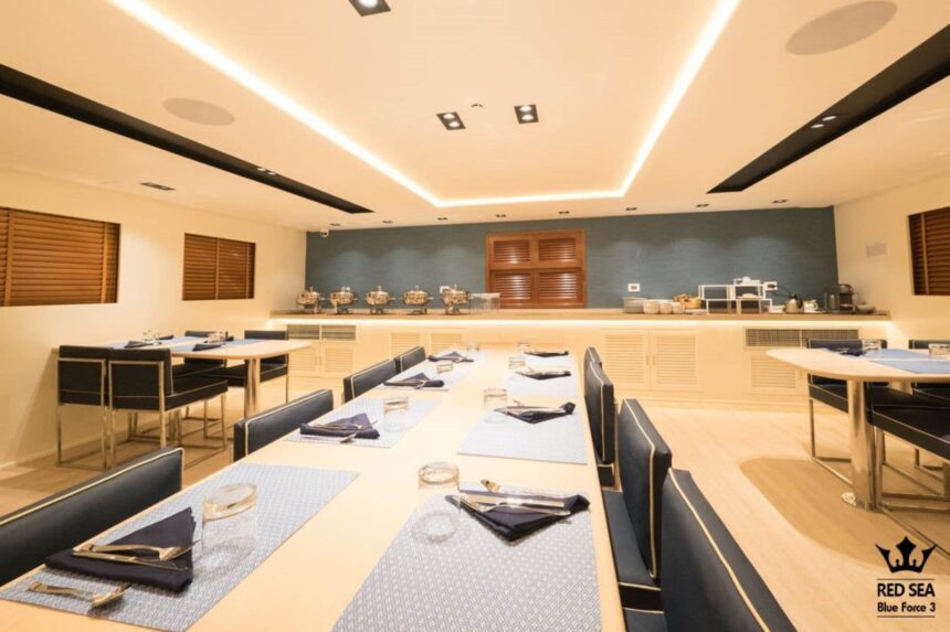 Formal dining room aboard the Blue Force 3 set with tables, napkins and a buffet counter