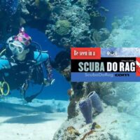 Scuba diver swimming past a coral archway with a ScubaDoRag banner ad overlaid on the image