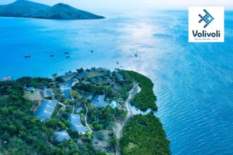 Aerial view of Volivoli Beach Resort's Fiji coastline with boats anchored offshore