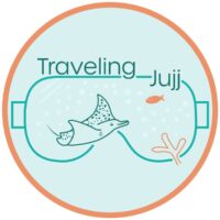 Traveling Jujj logo with a stylized dive mask outline framing a ray and a fish