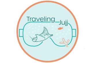 Traveling Jujj logo with a stylized dive mask outline framing a ray and a fish