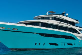 The liveaboard yacht Turquoise, with a bright turquoise hull, sitting on calm blue Red Sea water