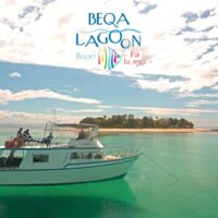 Dive boat carrying divers anchored off a small island at Beqa Lagoon Resort in Fiji