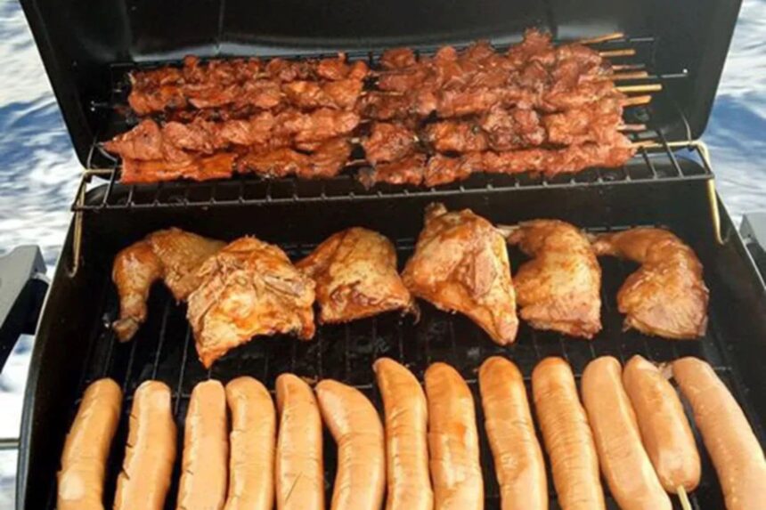 grilled skewers, chicken, and sausages cooking on an open barbecue at sea