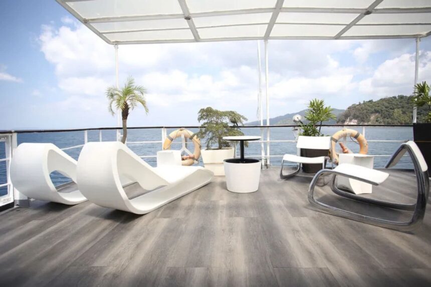 Shaded lounge deck with white pod chairs and a palm plant aboard Stella Maris Explorer