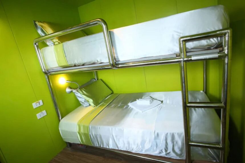 Twin bunk beds in a green cabin aboard Stella Maris Explorer