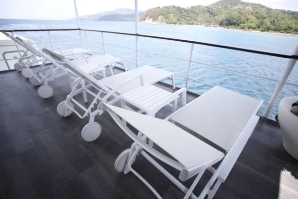 Row of white sun loungers on Stella Maris Explorer's deck with a coastline view