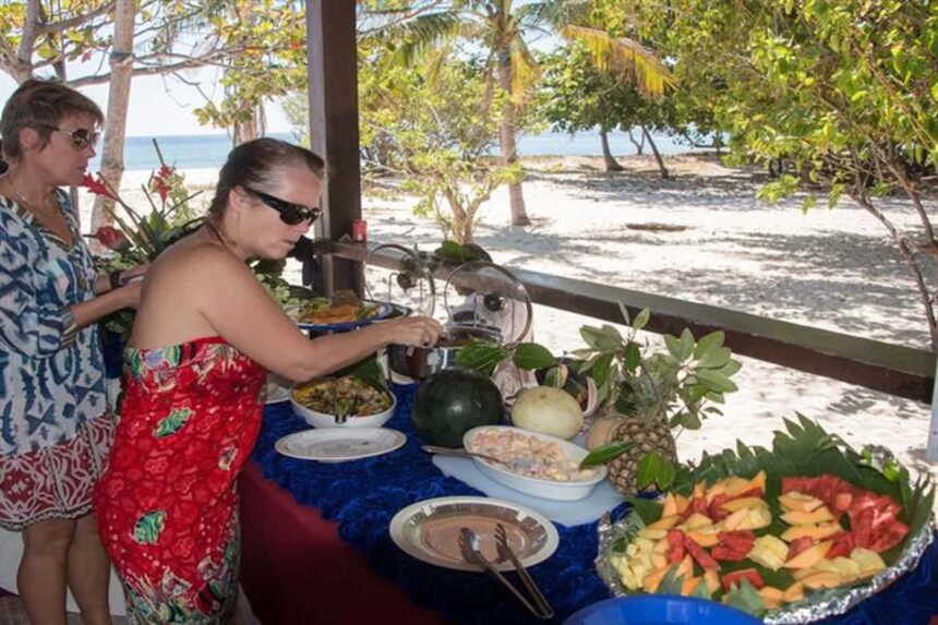 guests browsing a beachside buffet of tropical fruit during a Discovery Palawan shore excursion