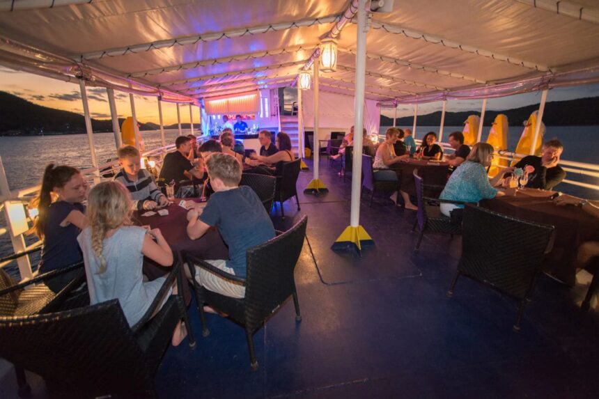 guests dining together on Discovery Palawan's sundeck at sunset
