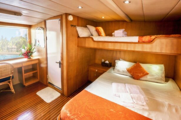cabin aboard Atlantis Adventurer with a bunk bed dressed in orange linens