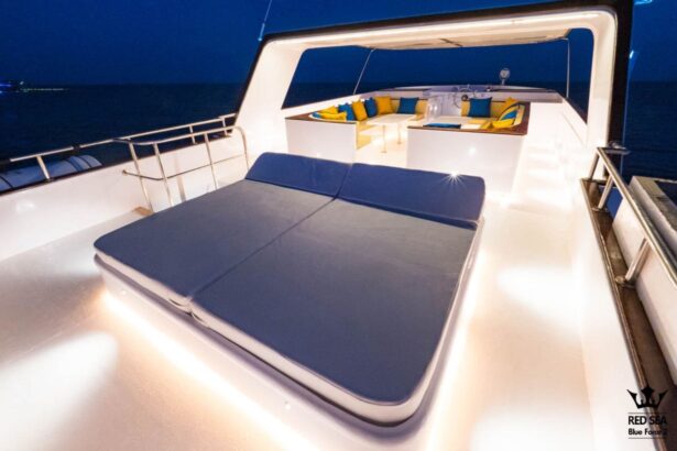 cushioned lounge bed on Red Sea Blue Force 2's sundeck lit up at night