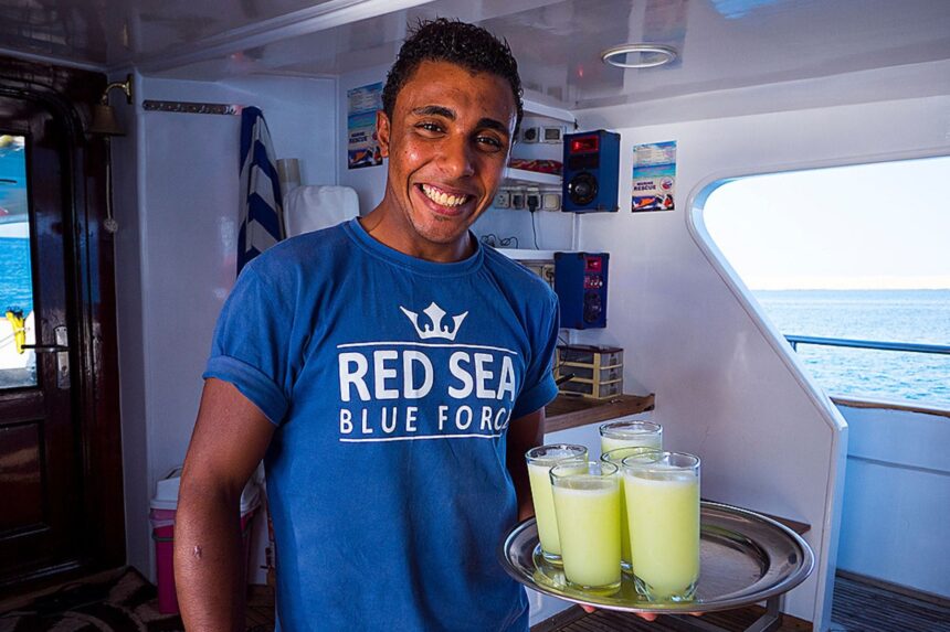 crew member serving a tray of fresh juice aboard Red Sea Blue Force 2