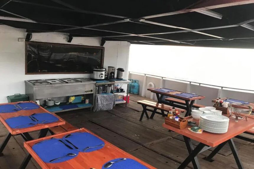 Outdoor dining tables set up under a canopy aboard the M/Y Resolute