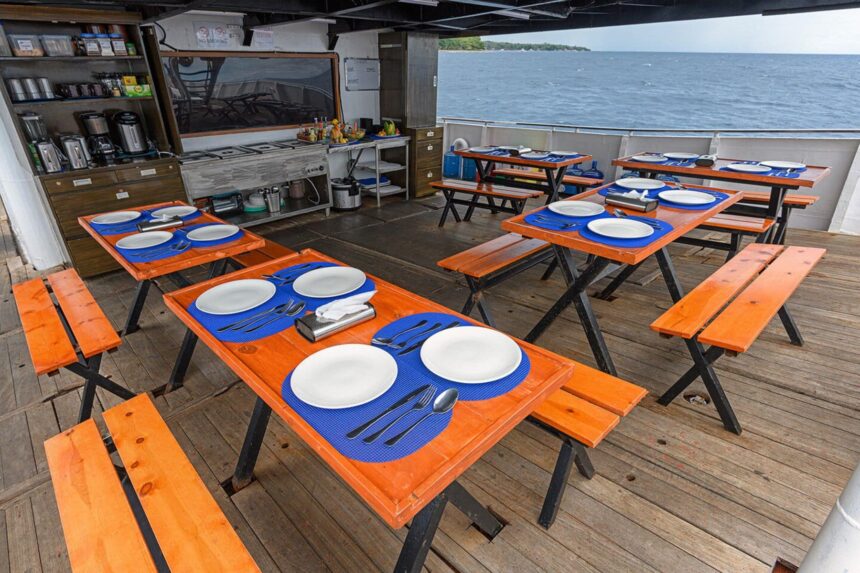 Dining tables set for a meal with ocean views aboard the M/Y Resolute
