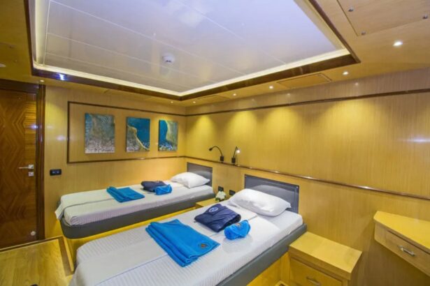 Twin-bed cabin aboard the Golden Dolphin IV liveaboard with wood paneling and reading lights