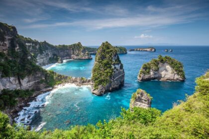 Limestone sea stacks and turquoise coves along the cliff lined coast of Nusa Penida in Bali