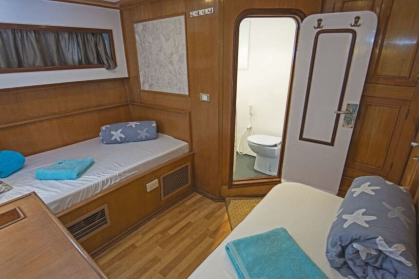 Twin cabin aboard the Golden Dolphin II with the en-suite bathroom door open