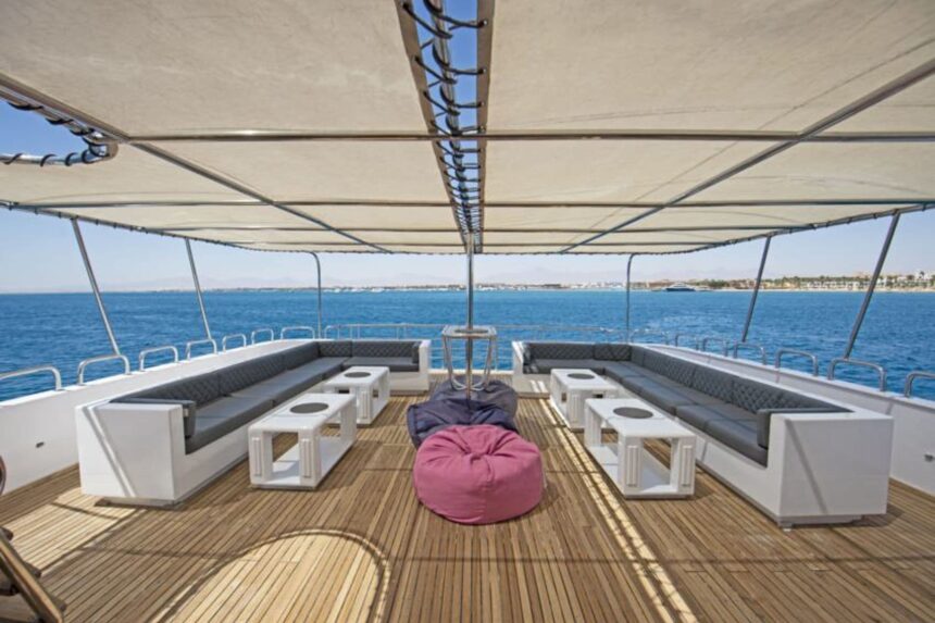 Shaded lounge deck with white sofas and a pink bean bag aboard the Golden Dolphin II