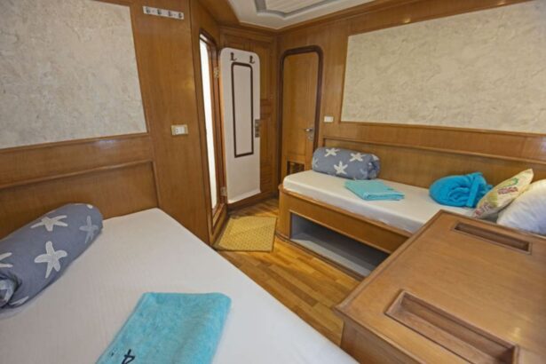 Twin beds with folded towels in a wood-paneled cabin aboard the Golden Dolphin II