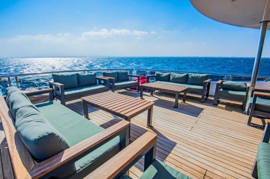 Outdoor deck seating with green cushions overlooking the sea aboard the SS Glorious Miss Nouran