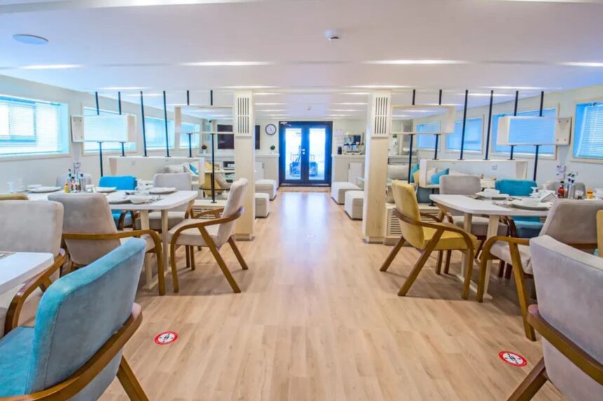 Dining lounge with blue and yellow chairs aboard the SS Glorious Miss Nouran liveaboard