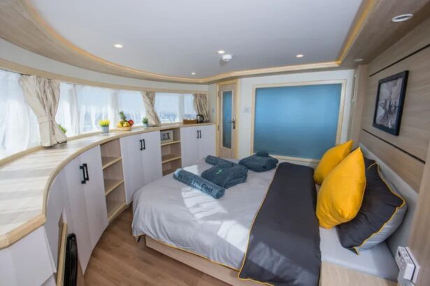 twin cabin aboard the SS Glorious Miss Nouran with yellow pillows and curved cabinetry