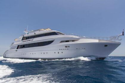 Golden Dolphin III liveaboard yacht cutting through the water, bow-on view