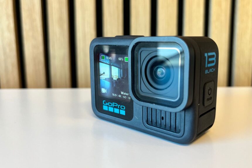 GoPro HERO13 Black standing on a desk showing a live preview on its front screen