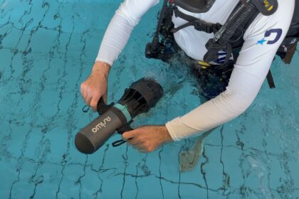 DIVEIN tester gripping the Asiwo U1 sea scooter while kneeling in a pool