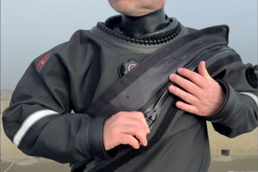 Our reviewer pulling the diagonal chest zipper closed on the Hollis DX-300X drysuit