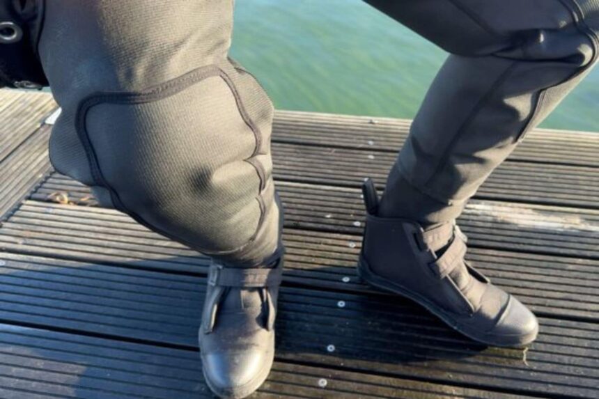 Rock Boots On The Hollis DX-300X Hollis DX-300X drysuit legs and rock boots seen from the side on a wooden jetty