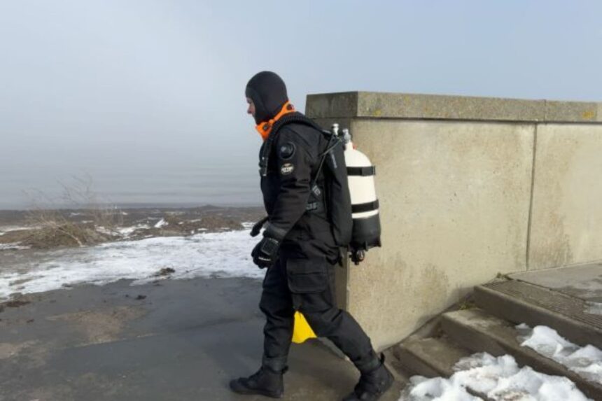 Otter Britannic Mk2 Walking To Entry Our tester walking a cylinder along a misty seawall in the black Otter Britannic Mk2 Telescopic drysuit