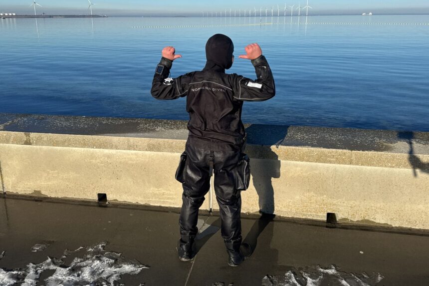 Northern Diver HID Drysuit Back View Back view of the Northern Diver HID drysuit at the water, showing the hood, shoulders and thigh pockets