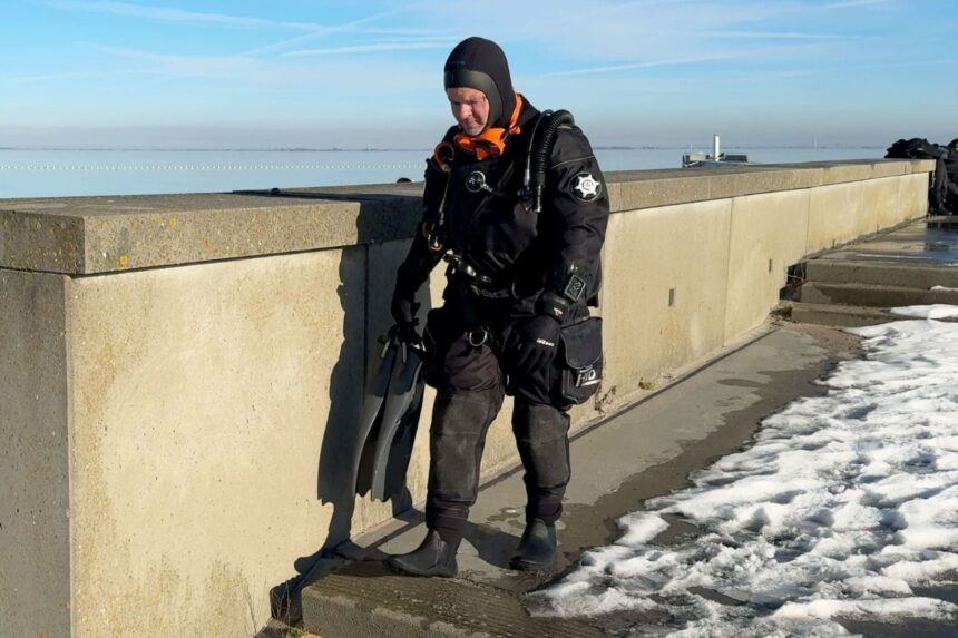 Northern Diver HID Drysuit Boots Our tester stepping down a seawall in the Northern Diver HID drysuit wearing attached drysuit boots