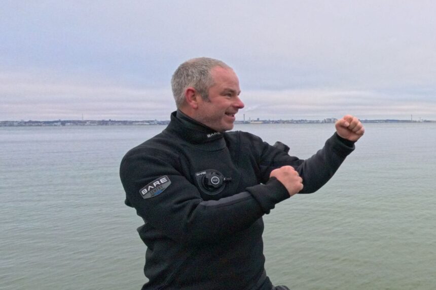 BARE Sentry Tech Wrist Seals Our reviewer flexing an arm to show the wrist seal and cuff of the BARE Sentry Tech drysuit