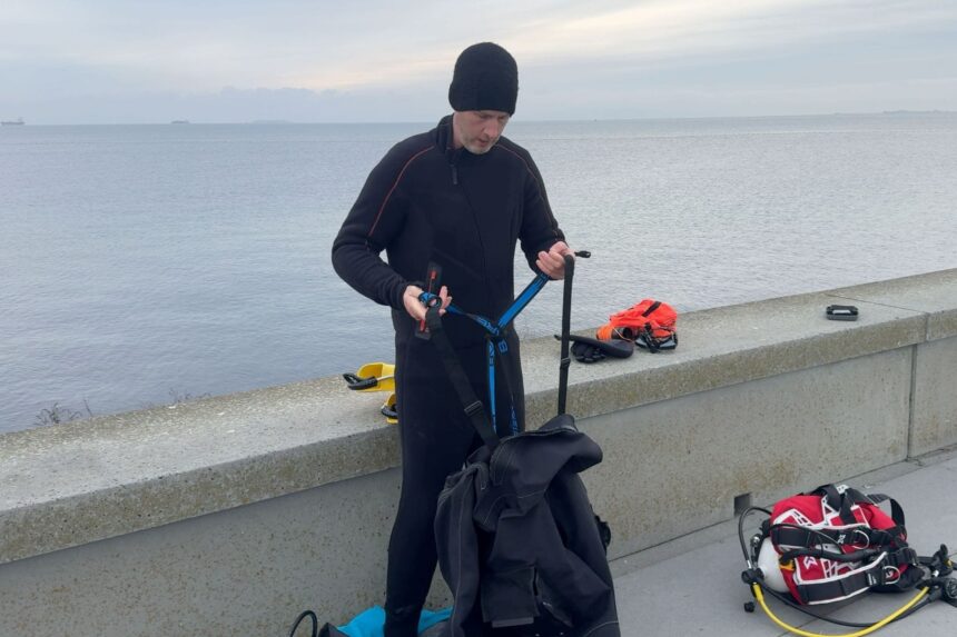 BARE X-Mission Evolution Suspenders Our reviewer adjusting the suspenders of the BARE X-Mission Evolution drysuit on a seawall
