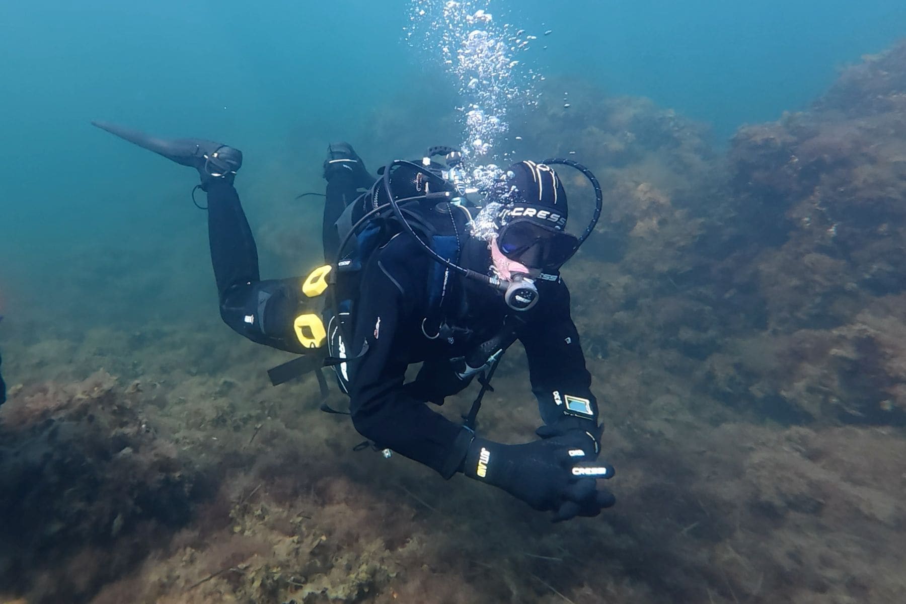 DIVEIN tester holding a flat horizontal trim underwater in the Cressi Desert drysuit