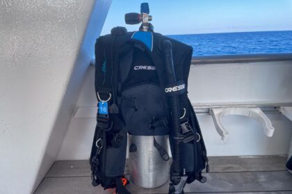 Cressi Elettra BCD rigged to a cylinder on a dive boat deck, showing the front D-rings