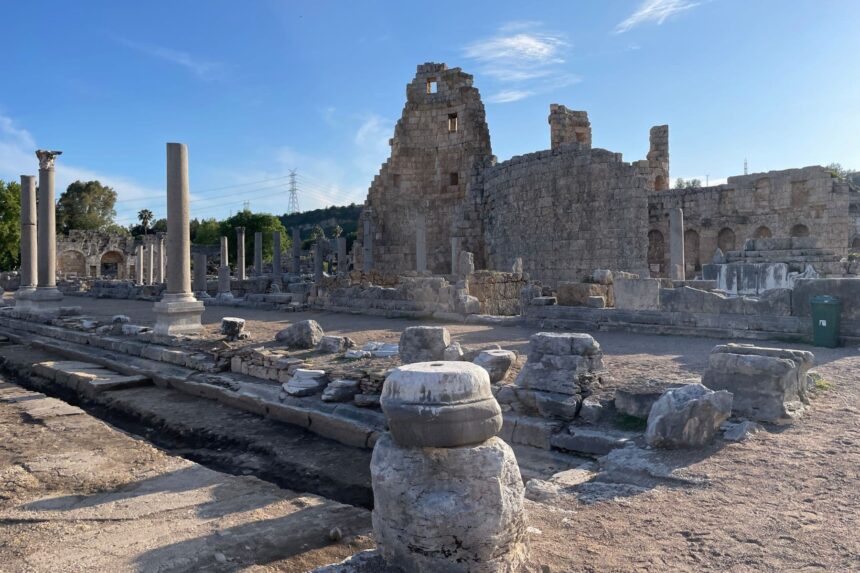 Ancient stone columns and ruined walls at Perge in Turkey under a clear blue sky