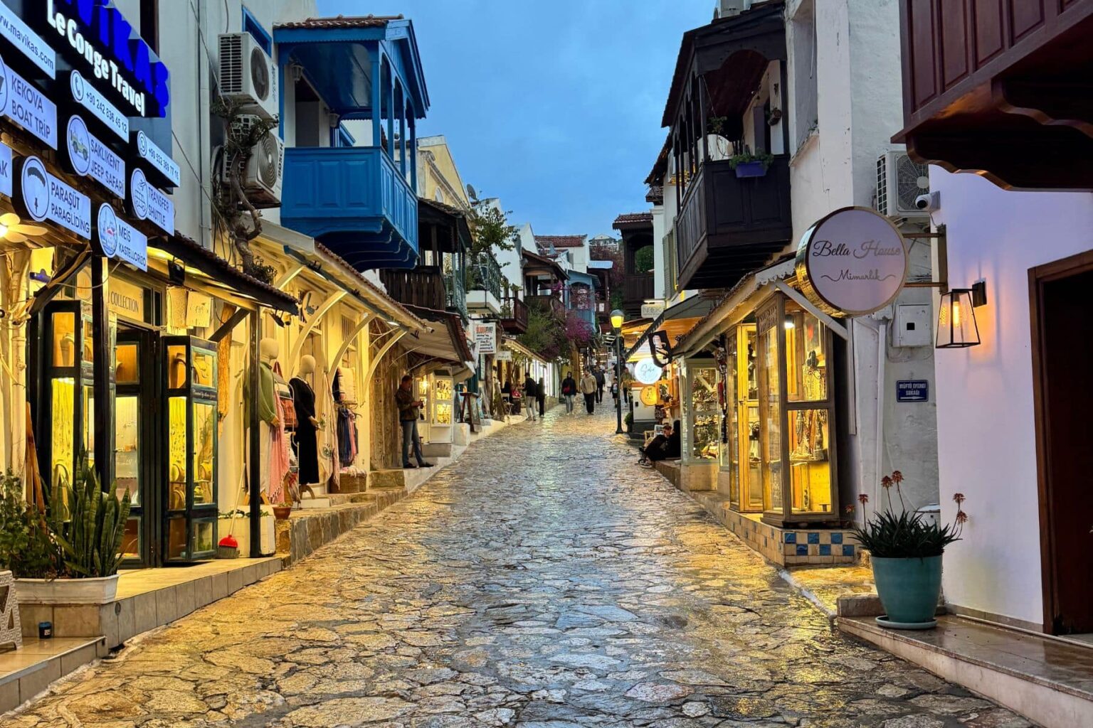 Lamp-lit cobblestone shopping street in the town of Kas, Turkey, at dusk