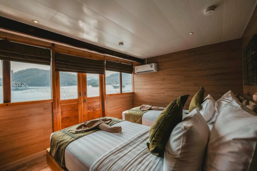 twin cabin with two beds and large windows aboard the Indo Master liveaboard